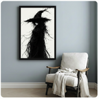 Black framed art poster of an ethereal gothic witch with tangled dark branches and a wide pointed hat, styled above a white linen armchair in a minimalist blue-gray room