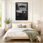 Oversized framed black and white gothic wall art of witches and a black cat on a misty beach, displayed above a neutral linen bed in a Scandinavian-style bedroom
